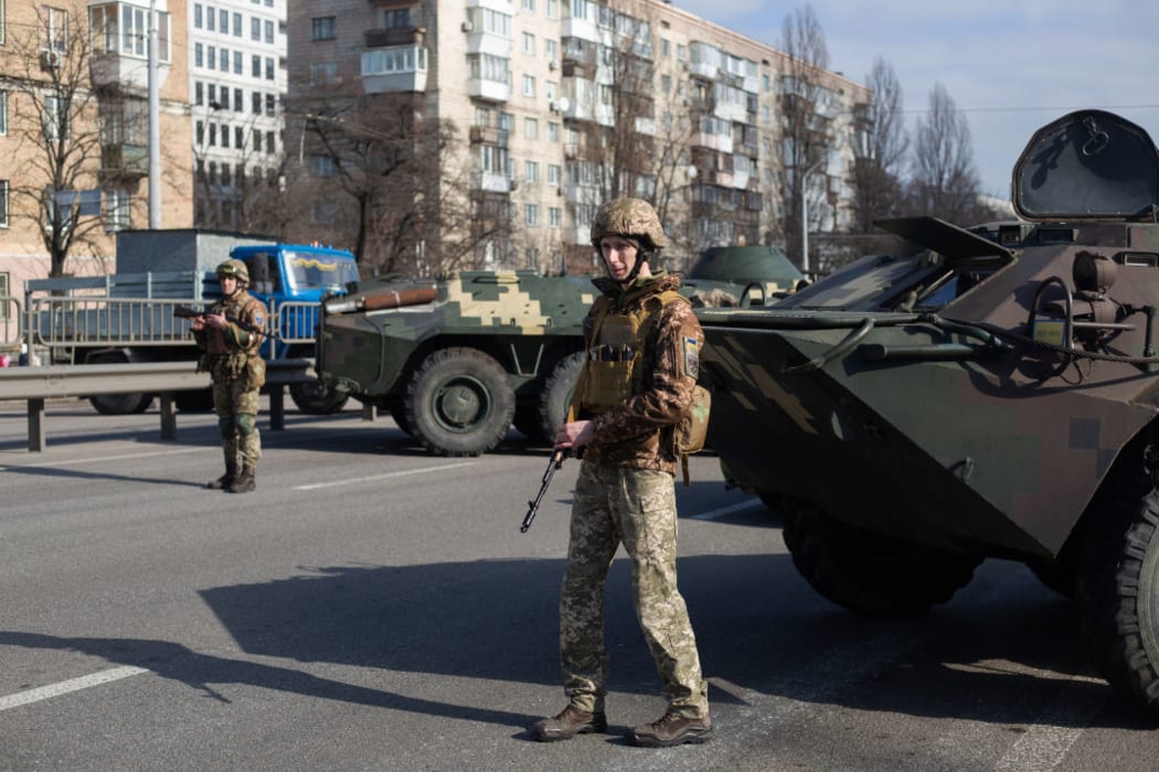 KYIV, UKRAINE - FEBRUARY 25: Ukrainian servicemen stand on patrol at a security checkpoint on February 25, 2022 in Kyiv, Ukraine.