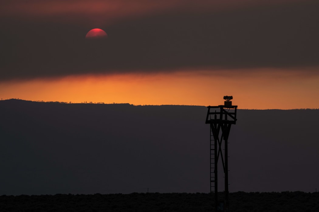 The sun glows behind smoke from the Oregon Bootleg Fire, just before sunset on 23 July, in Paisley, Oregon.