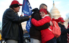Gary Phaneuf, Tony Naples and Melody Black share a moment together as they visit a memorial setup near the U.S. Capitol Building for Ashli Babbitt who was killed in the building after a pro-Trump mob broke in on January 07, 2021 in Washington, DC.