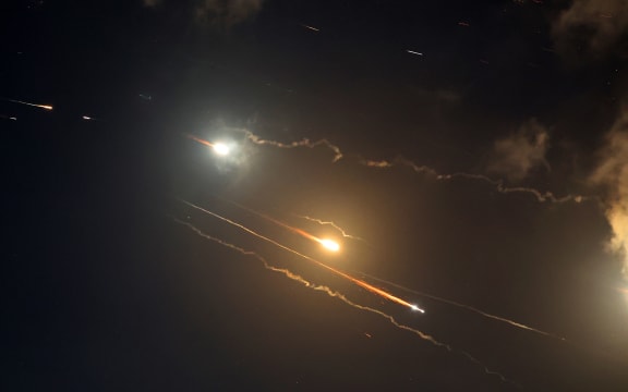 Rocket trails are seen in the sky above the Israeli coastal city of Netanya amid a fresh barrage of Iranian missile attacks on June 16, 2025. Israel's military warned on June 16 that it had detected a new missile salvo from Iran, saying its defensive systems were working against the threat. (Photo by JACK GUEZ / AFP)