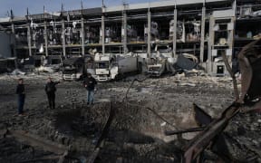 Law enforcement officers inspect a crater next to the heavily damaged logistics hub of the Novus supermarket following Russian missiles and drones strikes in Kyiv on 25 November, 2025, amid Russian invasion in Ukraine.
