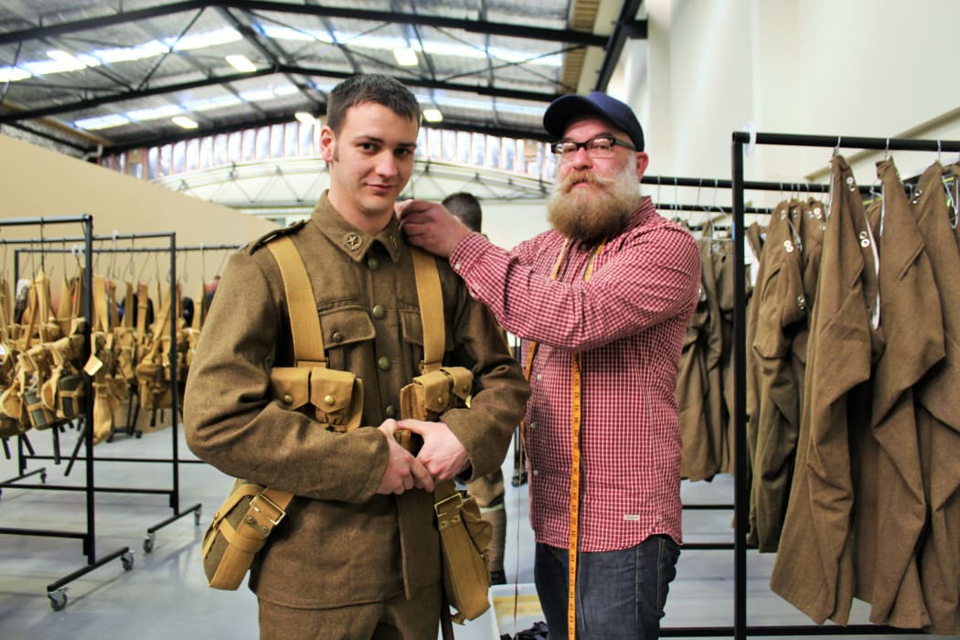 Private (PTE) Simon Adams is fitted into his replica First World War uniform, supplied by WingNut Films, by costume assistant Paul Booth.
