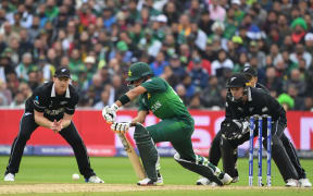 Pakistan's Babar Azam is watched by Black Caps James Neesham and Tom Latham as he plays a shot during the 2019 Cricket World Cup group stage match.