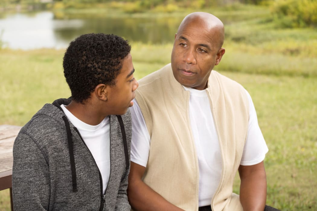 A photo of a father and son having a serious discussion.