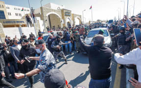 People stand on the side as Jordan's King Abdullah II arrives at al-Hussein New Salt Hospital in the town of Salt.
