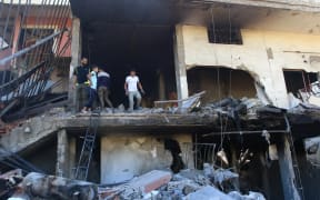 People inspect the debris at the site of an overnight Israeli strike on a house in the southern Lebanese village of Akbiyeh on September 24, 2024. Israel announced dozens of new air strikes on Hezbollah strongholds in Lebanon on September 24, a day after 492 people, including 35 children, were killed in the deadliest bombardment since a devastating war in 2006. (Photo by Mahmoud ZAYYAT / AFP)