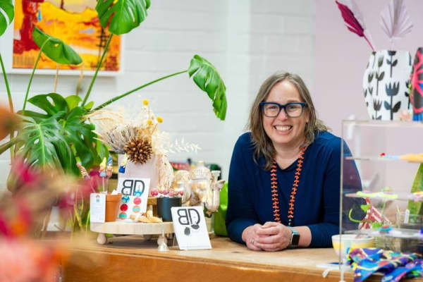 Tamara Campbell is a smiling brown-haired woman surrounded by plants.