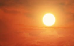 Glowing sun on the sky to illustrate heatwave or global warming.