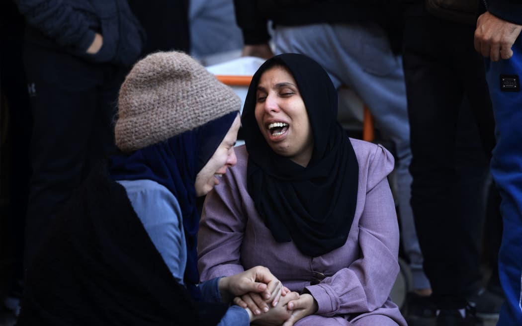 A woman (R) mourns her husband, killed when the tent where the Salah and Abu Hatab families were sheltering was hit by Israeli bombardment, at the morgue of the Nasser medical centre in Khan Yunis in the southern Gaza Strip, on January 4, 2024, as battles between Israel and Palestinian Hamas militants continue.