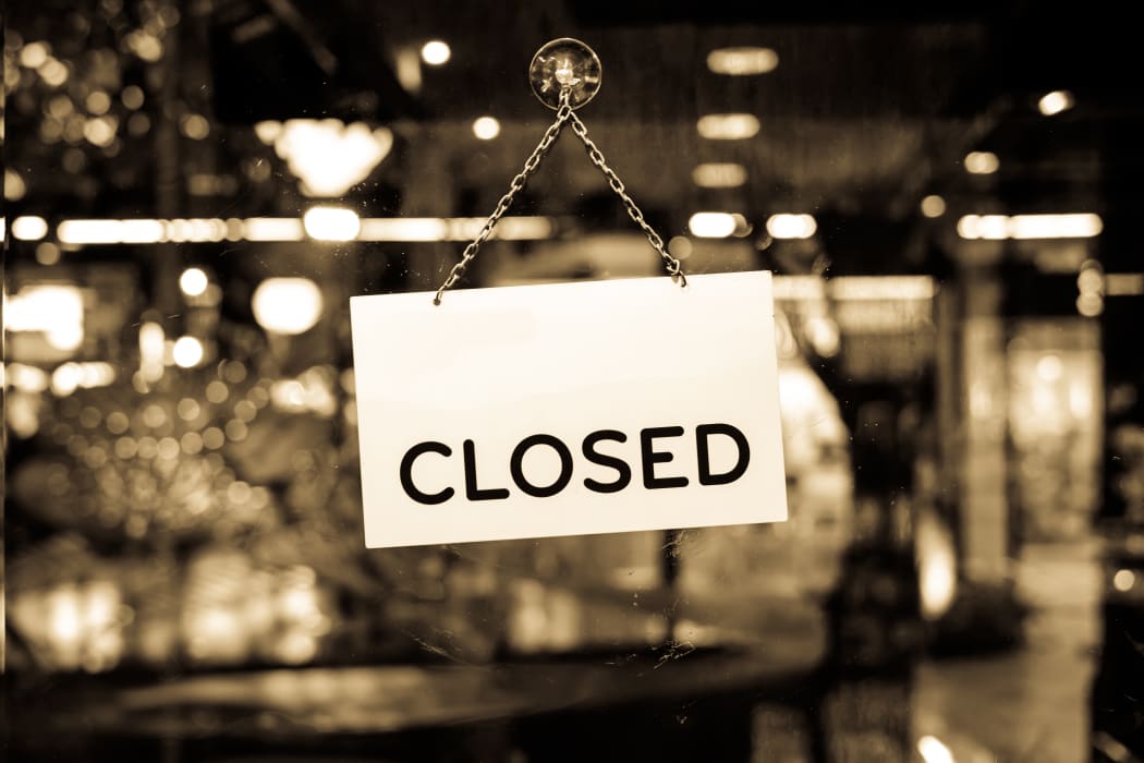 A closed sign hanging in a shop window