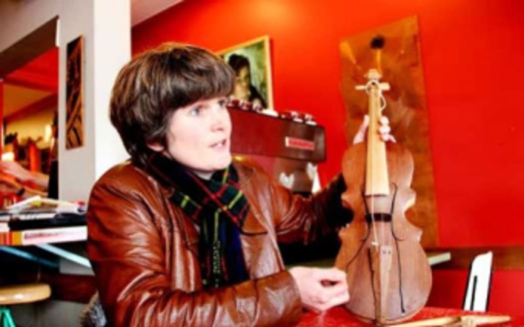 Megan Collins holding a rabab, used in West Sumatra to accompany migration stories