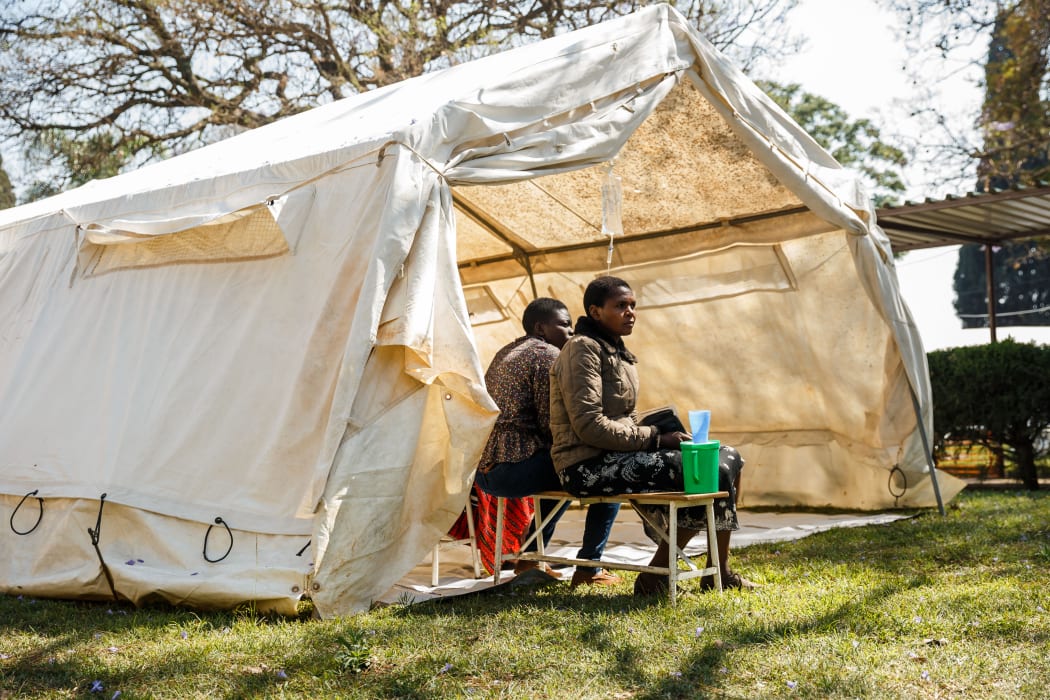 Cholera patients wait for treatment outside a tent during a visit of Zimbabwe Minister of Health, at the cholera treatment centre of the Beatrice Infectious Diseases Hospital, in Harare, on September 11, 2018.