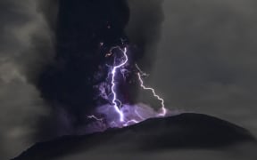 Mount Ibu spewing volcanic ash as lightning strikes, as seen from the monitoring post in Indonesia's West Halmahera, North Maluku, on 18 May, 2024.