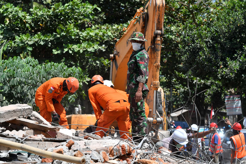 Members of an Indonesian search and rescue team look for victims of the recent quake on Lombok island.