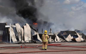 The Kerikeri tyre shop was still burning, but contained, by noon. Photo: RNZ / Peter de Graaf