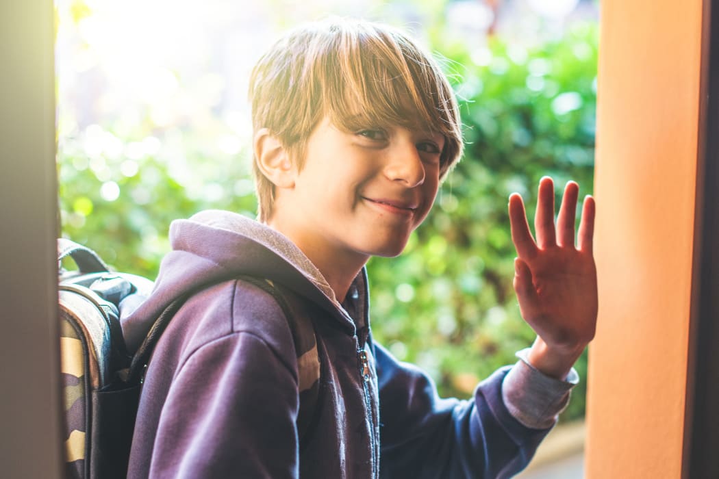 Young boy greets as he leaves home to go to school New day of ordinary life