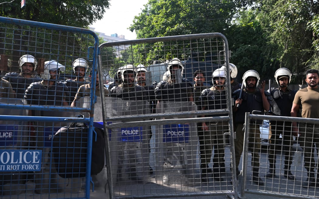Policemen stand guard outside the closed campus of Punjab College, in Lahore on October 15, 2024. - A college campus in Pakistan's eastern city of Lahore was shut down on October 14, by the provincial government after reports spread online that a student had been raped, sparking demonstrations. (Photo by Arif ALI / AFP)