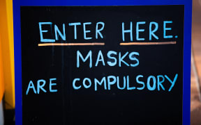 Sign outside a business which reads "Masks are compulsory"