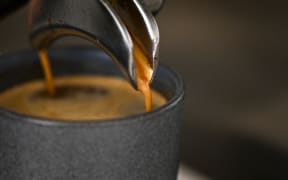 A worker prepares a cup of coffee at a coffee shop in Buenos Aires, on July 19, 2022. Argentina does not produce coffee, it imports it, but the coffee shops in Buenos Aires are an institution that identifies the city and there is even a list of "notable coffees". In the midst of the currency crisis, rise in international prices of raw materials and increase in freight costs, plus a sharp drop in international reserves, Argentines wonder if their daily habits are at risk. (Photo by Luis ROBAYO / AFP)