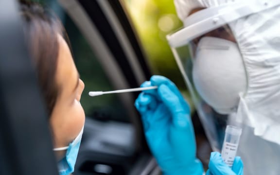 Portrait of asian woman drive thru coronavirus covid-19 test by medical staff with PPE suit by nose swab. New normal healthcare drive thru service and medical concept.