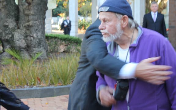 The protester being restrained by court security staff.