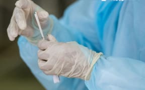 A health worker puts swabs into a tube after collecting a sample for Covid-19 testing at Sunway Medical Center in Subang Jaya, on the outskirts of Kuala Lumpur, on October 22, 2020.