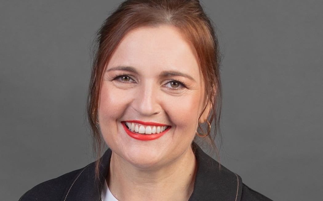 Smiling portrait of Charlotte Ryan on grey background