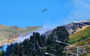 A helicopter fighting a fire in the Port Hills on 20 November 2023.