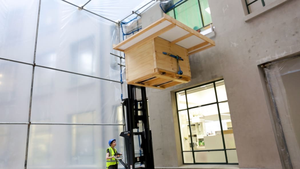 Lowering one of the many cloak trays to transport to the new storage.