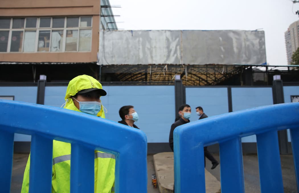 Chinese security guards check at the gate of Huanan Seafood Wholesale Market  after a vehicle carrying members of World Health Organizaion (WHO) entered the market.