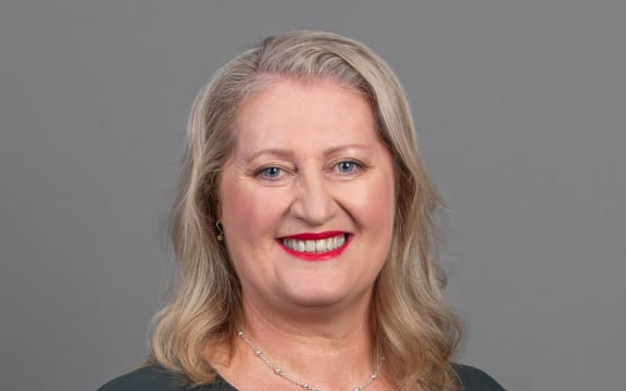 Kate Gudsell smiling with grey background