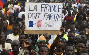 Protesters hold an anti-France placard during a demonstration in Niger's capital Niamey on 3 August, 2023. Niger's junta said the same day that it was scrapping military pacts made between Niamey and France, following its coup the week prior.