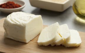 Piece of fresh sliced halloumi on a cutting board