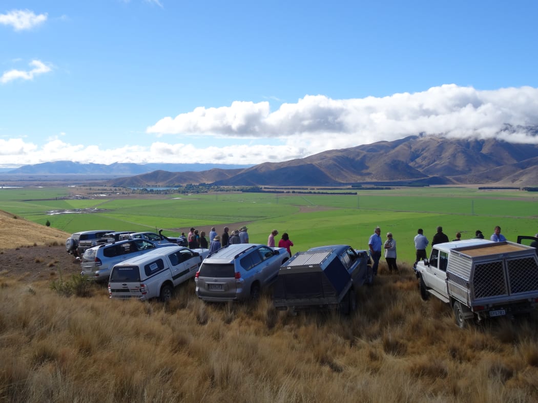 Farmers inspect the results of irrigation in valley basins in the South Island High Country.