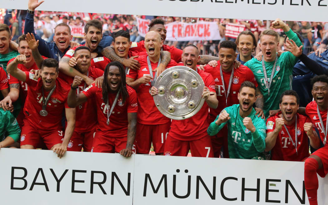 Bayern Munich's players and the team pose with the trophy after the German First division Bundesliga football match FC Bayern Munich v Eintracht Frankfurt in Munich, 2019.