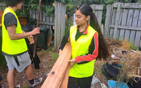 Māngere College student carrying wood for new compost bin.