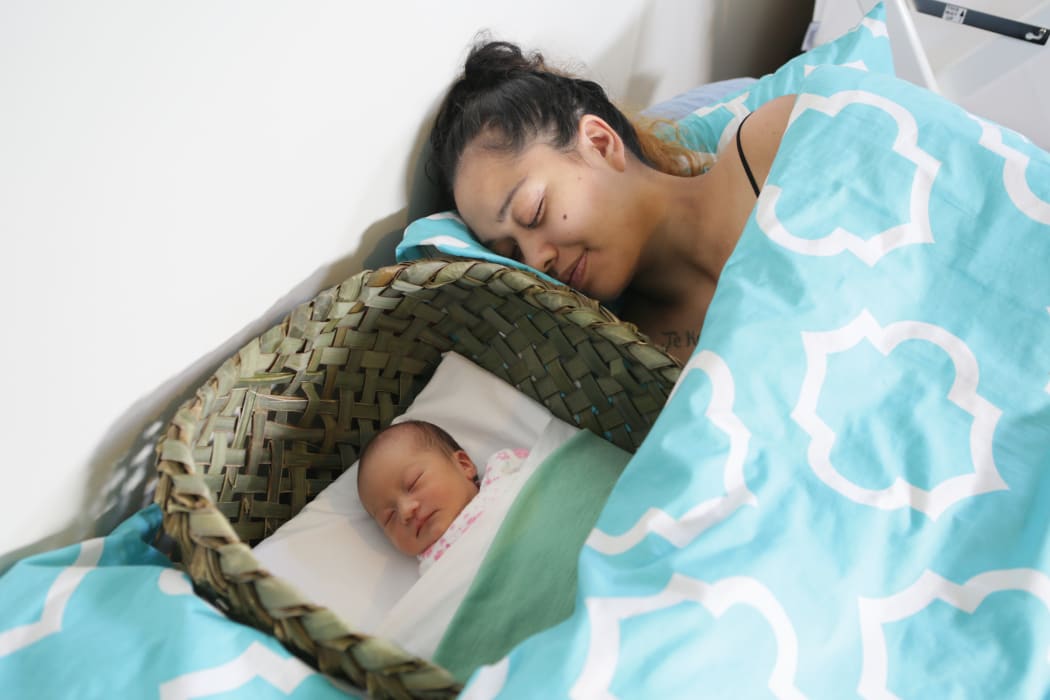 Aniwa Pitman-Clark with six-day-old Jypsy-Rain Pitman Martin sleeping safely in her wahakura.