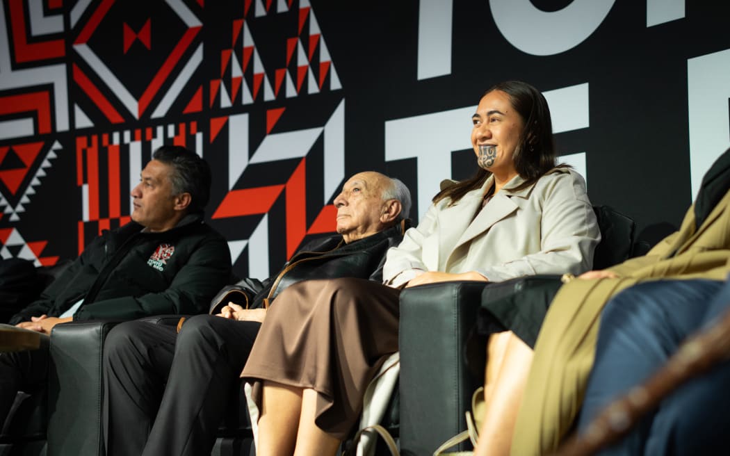 Te Arikinui Kuini Nga wai hono i te po on stage with Sir Tīmoti Kāretu and Bayden Barber.