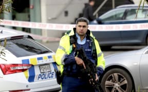 Armed police remain at the cordon of a serious shooting incident in downtown Auckland on 20 July, 2023.