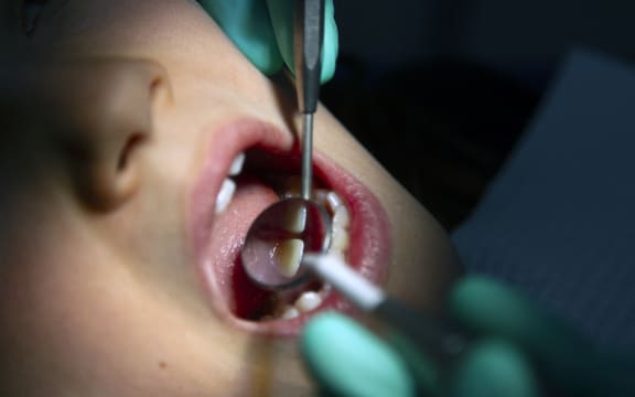 A dentist provides dental care to a girl.