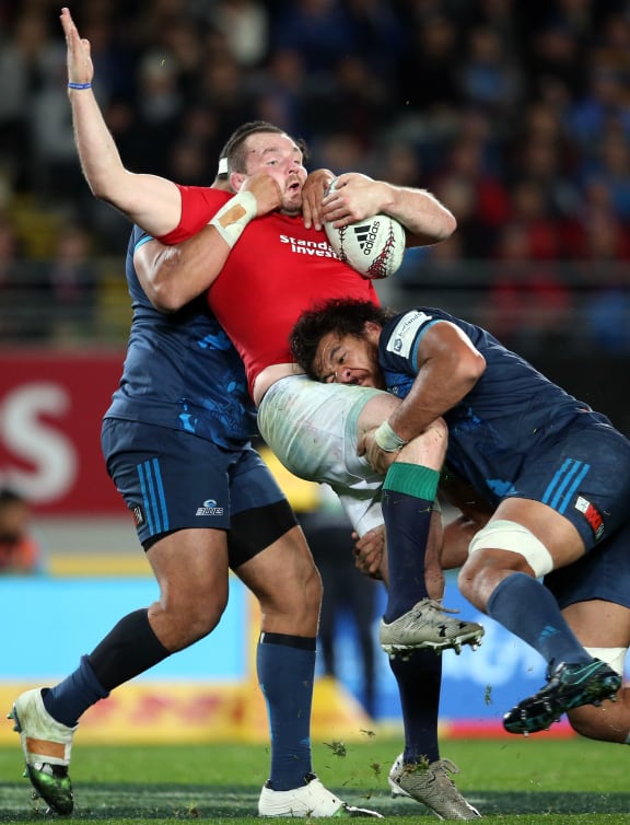 British and Irish Lions captain Ken Owens (C) is tackled by Blues' Alex Hodgman (L) and Steven Luatua (R) during the rugby match between The British and Irish Lions and Auckland Blues at Eden Park.