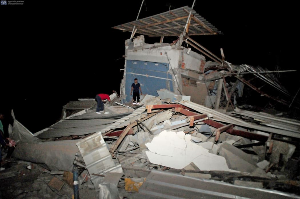 Residents survey destroyed housing.