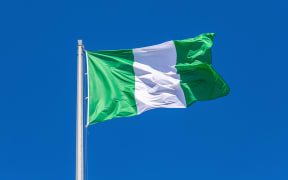Flag of Nigeria waving in the wind against the blue sky