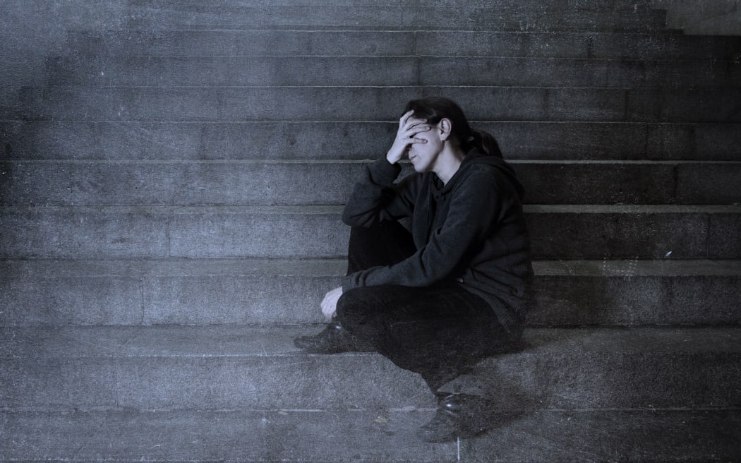 sad woman alone on street subway staircase suffering depression looking sick and helpless sitting lonely as female victim of abuse concept  in  dark urban night grunge background grunge dirty edit