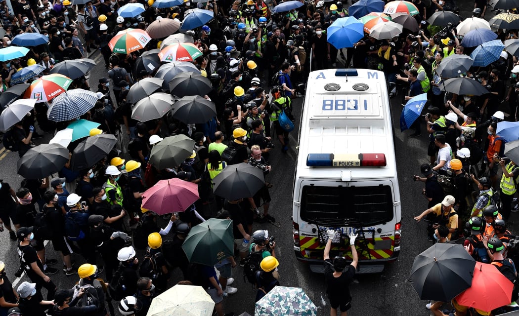 Protesters block a police van during a demonstration in the district of Yuen Long in Hong Kong on July 27, 2019. -