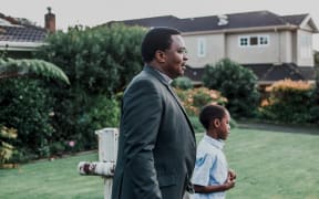 (L-R) Amos Muzondiwa and his son Ben walk to church in Ōwairaka, Auckland.