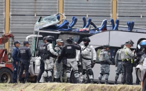 National Guard members and army soldiers arrive at the scene of an accident involving a passenger bus and a train in Atlacomulco, Mexico State, on September 8, 2025. According to the State of Mexico attorney general office, seven women and three men were killed in the accident. (Photo by Ramses VLADES / AFP)