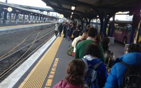 People queue for buses at the train station in Wellington.