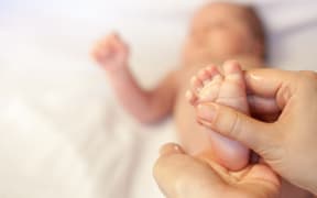Mother massaging baby