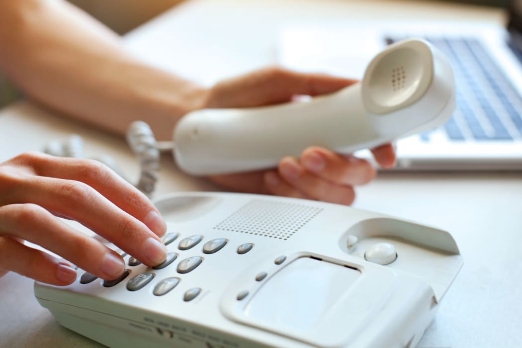 A person dials a number on a home landline phone (file)